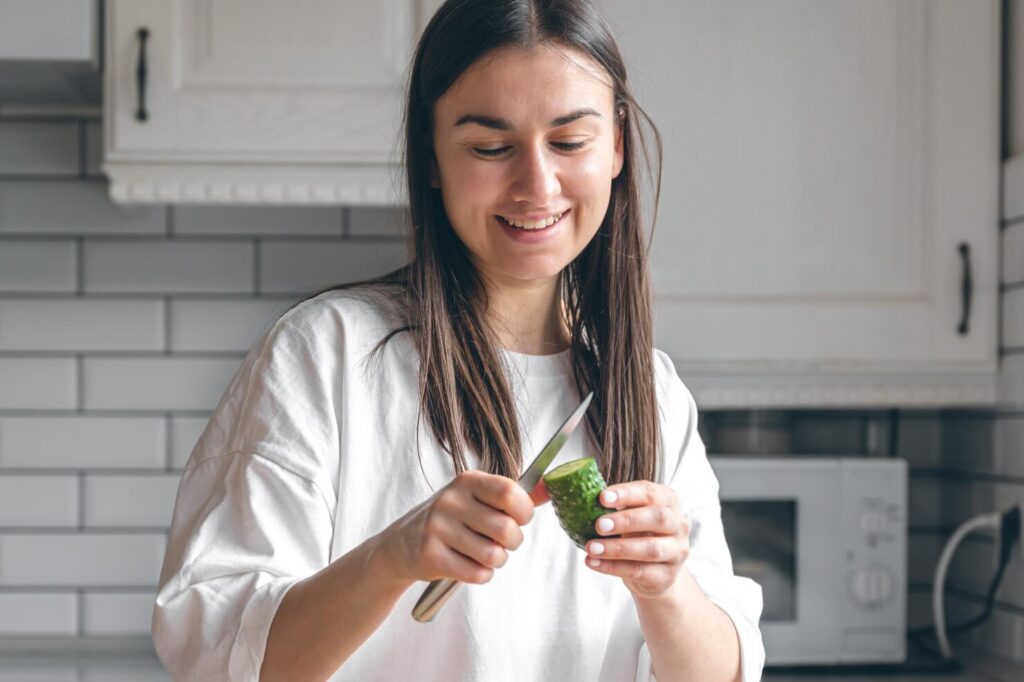 attractive-young-woman-cutting-vegetables-salad-kitchen
