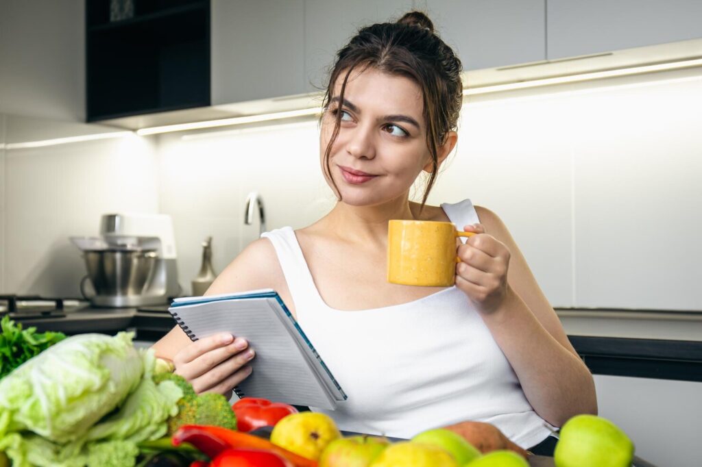 young-woman-kitchen-with-notebook-her-hands-chooses-recipe